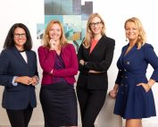 Vier Frauen stehen zusammen und lächeln in die Kamera. Eine der Frauen ist Christiane Holzinger, Event-Organisatorin und Moderatorin.